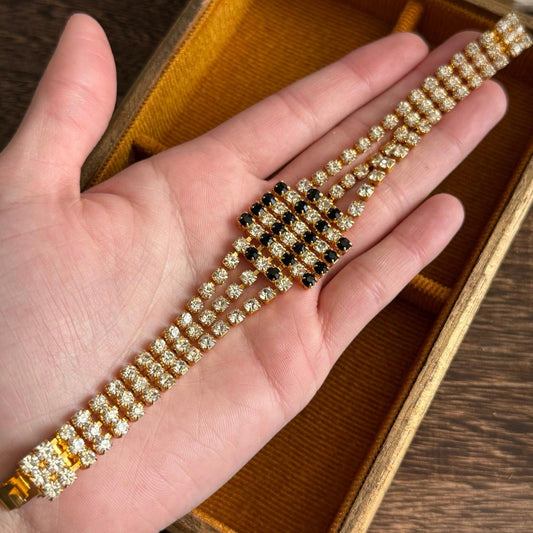 Gold-tone metal base with three rows of clear rhinestones bracelet